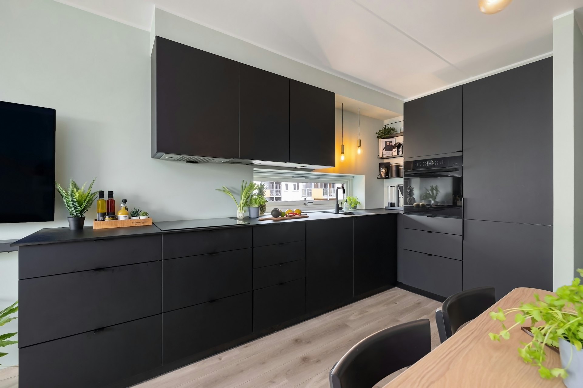 A kitchen with a table and a TV on the wall